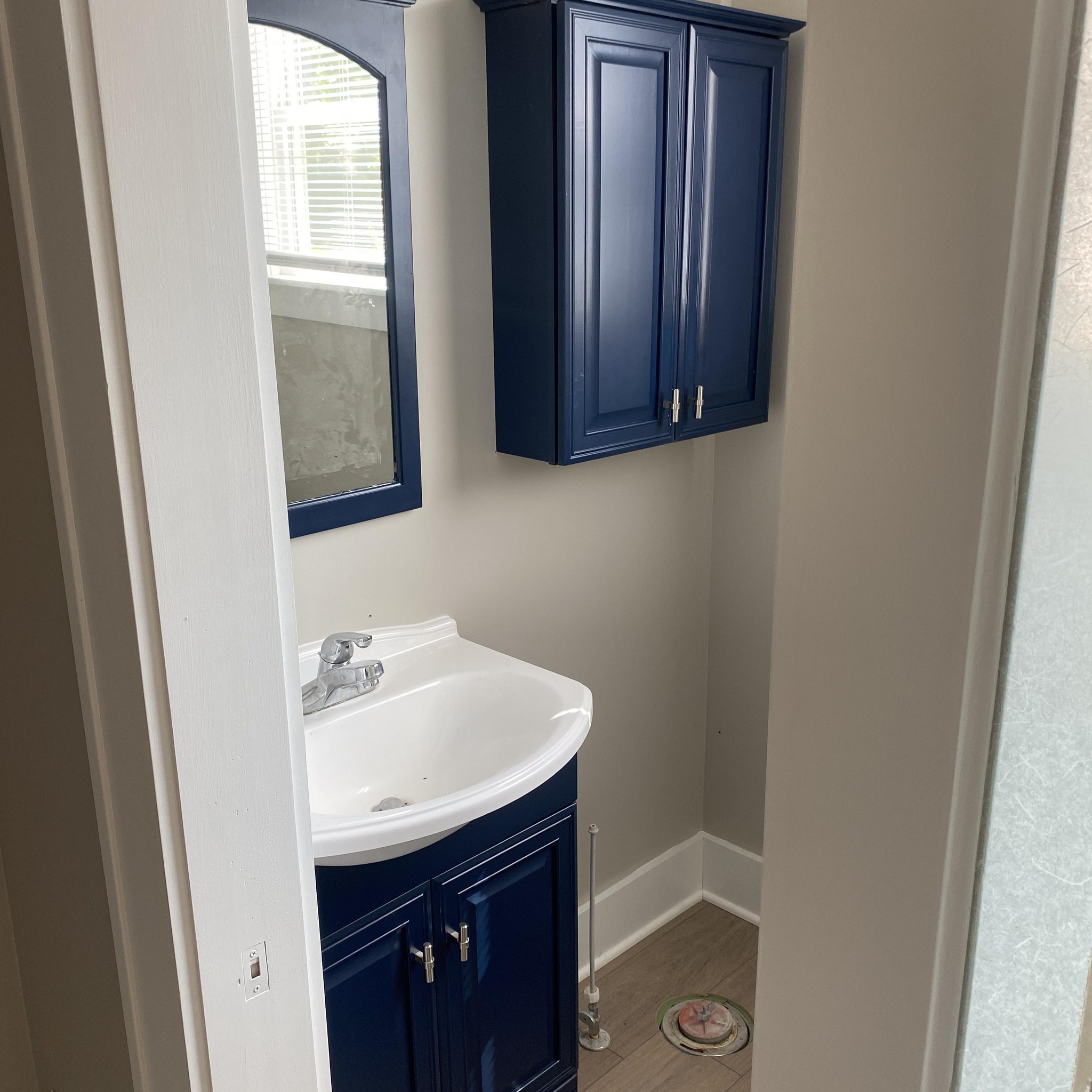 Refinished blue bathroom vanity with mirror and upper cabinet